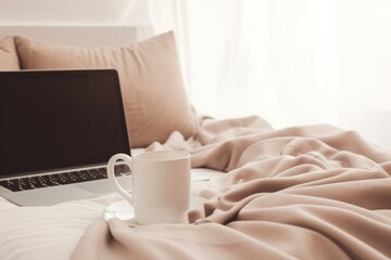Fototapeta na wymiar Laptop and coffee cup on light bed in bedroom.
