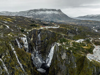 aerial view from drone of V&oslash;ringfossen waterfall with frozen walls of a cliff