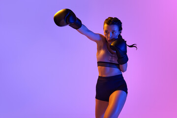Intense moment as determined boxer girl meticulously training, preparing for combat against...
