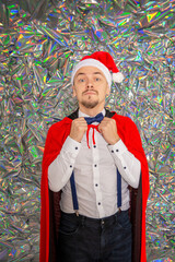 Handsome man wearing Santa hat wearing bow tie on the sparkle background. New Year style
