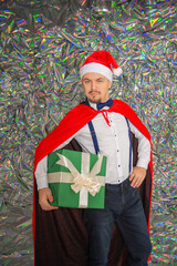Fototapeta premium Young handsome smiling man with Christmas gift box on the sparkle background