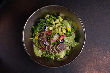 Delicious salad with tuna, avocado and arugula