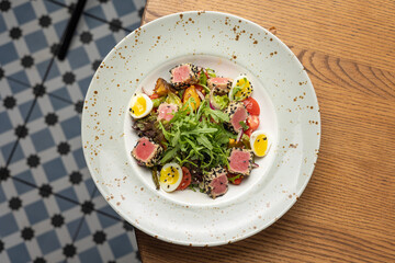 Delicious salad with tuna, egg, tomato and arugula