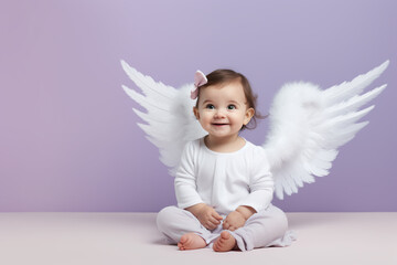 Adorable baby girl with angel wings sits on a pastel purple surface, bringing joy and innocence to the frame.