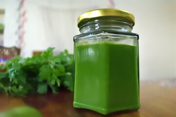 Glass Jar full of green mint chutney 
