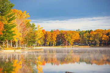 Obraz premium Extremely vibrant fall colors on trees at a lake in Michigan
