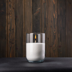 Paraffin candles in a glass flask on a dark background