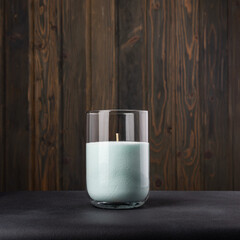 Paraffin candles in a glass flask on a dark background