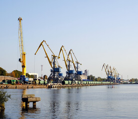 Fototapeta na wymiar Small freight sea port with cranes and containers in the Bay of Vyborg, Russia