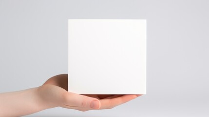 A person holding a white square in their hand