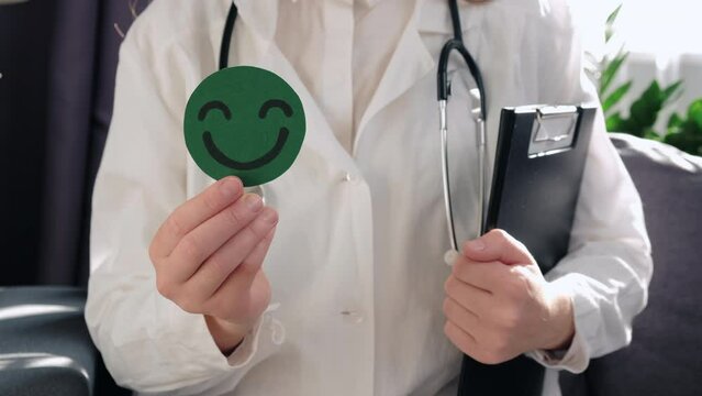 Unrecognizable professional doctor female in coat and stethoscope holding green happy smiley, satisfaction survey, mental health assessment, child wellness, world mental health day, Compliment Day