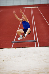 Determination evident in running long jump. Athletic man, sportsman frozen in air, following rules,...