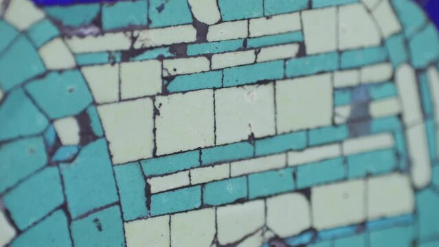 Closeup of mosaic of colored ceramic tile by Antoni Gaudi at his Parc Guell, Barcelona, Spain