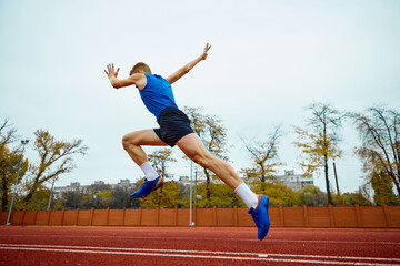 Dynamic steps leading to an impactful long jump. Bottom view full length portrait of professional...