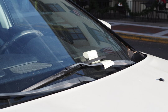 Their is a parking ticket under the windshield wiper.