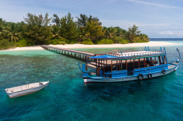 Fototapeta na wymiar Typical Maldivian Tourist Boat - Dhooni at Tourist Resort Island Pier in Republic of Maldives