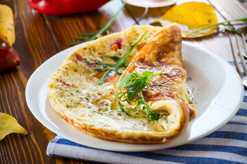 Fried omelettes with various autumn vegetables in a plate on a wooden table.