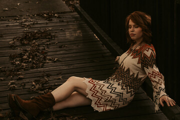 Fototapeta na wymiar Woman sitting on a wooden bridge