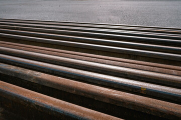 Many used rusty rails of different length stored at a ground for old rails replacement. Diagonal placement photo