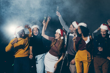 Group of young people dancing and smiling while celebrating New Year in night club together