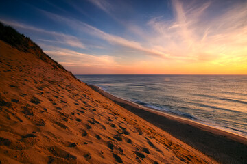 Sunrise paints the sky orange over the shoreline of Coastguard Beach; Cape Cod, Massachusetts, United States of America
