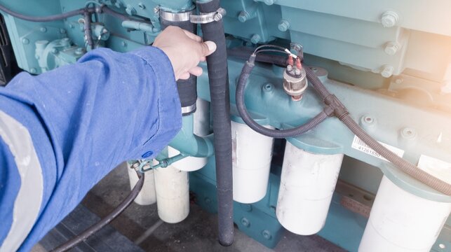 Technician hold the hosen engine breather on  engine diesel power generator. component crankcase  breather hose on the engine system.