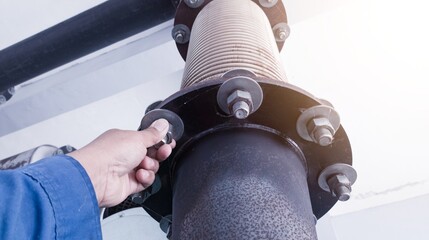 Technician check and inpection the bolt mounting exhaust muffler with flexible metal bellows on the...