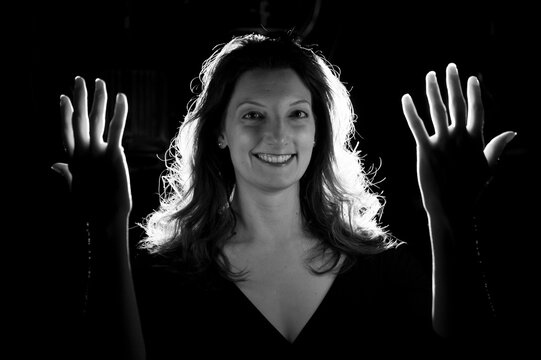 Young woman holds up her hands in the illuminating light; Lincoln, Nebraska, United States of America