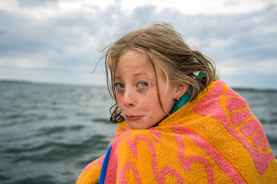 Girl shivers while on a boat ride at Leech Lake in Minnesota, USA; Walker, Minnesota, United States of America