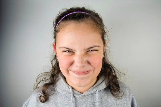 Portrait of a pre-adolescent girl making a funny face; Studio