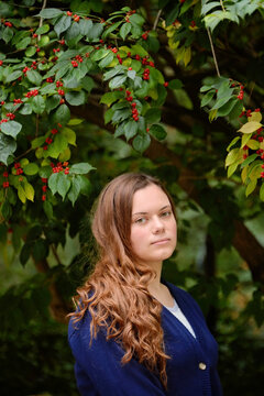 Teenage girl poses for a portrait in front of a flowering tree; Lincoln, Nebraska, United States of America