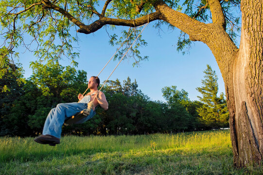 Man swings on a tree swing; Bennet, Nebraska, United States of America