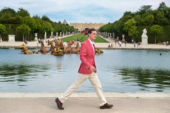 Young man walks in Versailles, France; Versailles, France