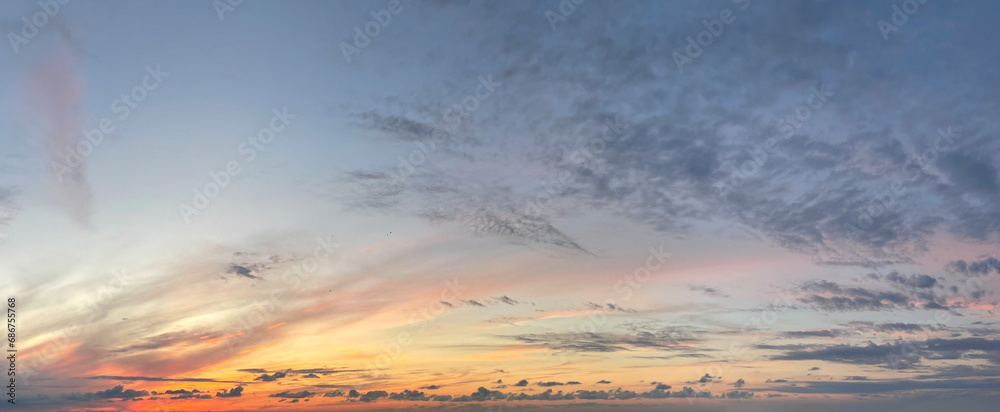 Wall mural beautiful sunrise with dark cloud, gold sun and blue sky. panoramic nature background
