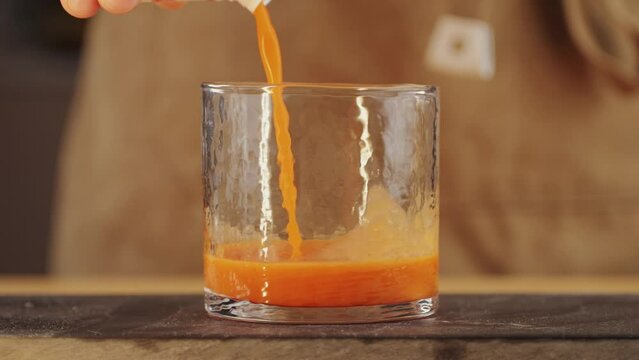Tomato gazpacho Spanish cold soup with pepper and garlic, Spanish traditional cuisine, chef cooking dinner with carrot juice.