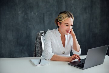 Stylish Female Working on Laptop Computer in a Company Office in the Evening. Young Manager