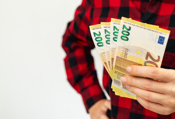 Female person holding 200 euro bills in her hand.