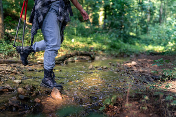 close up image of boots walking through water, hiking concept