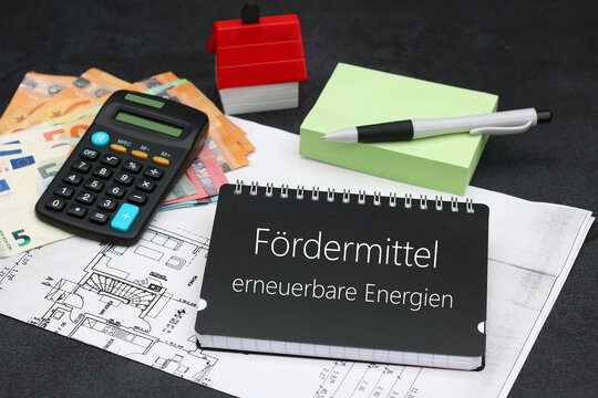 Euro Geldscheine und Taschenrechner mit dem Text F&ouml;rdermittel erneuerbare Energien auf einem Notizblock.
