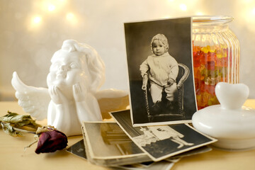 old family photographs, pictures from 1940, home archive documents on vintage wooden table, angel...