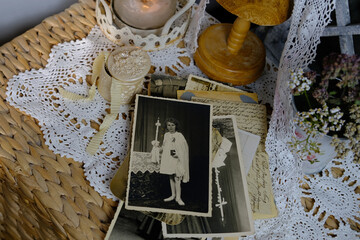 burning candle, lace, old chest of drawers shabby chic, stack of retro photos of 50-60s, dried...