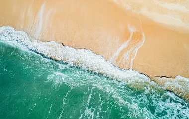  Aerial view of sandy beach and turquoise ocean. Top view of ocean waves reaching shore on sunny day. © Евгений Бахчев