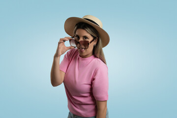 Woman in Casual Clothing and Straw Hat Standing on Colored Background