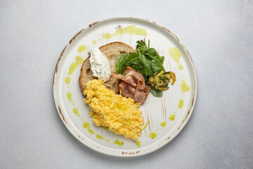 Delicious breakfast - Scrambled eggs with cheese, toast and meat