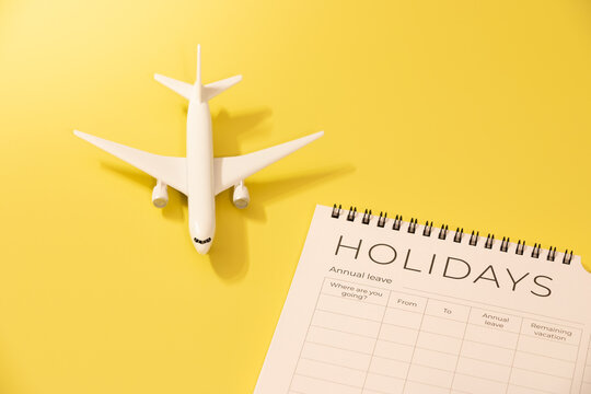 Holiday planning concept. Booking flight. Tourism. Summer holiday. Travel destinations. Toy airplane next to calendar.