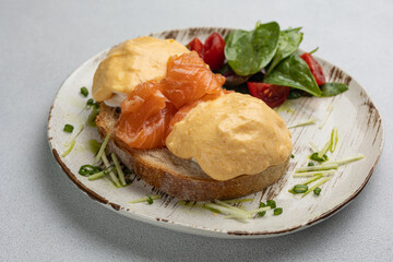 Delicious breakfast - Eggs Benedict with salmon and tomato