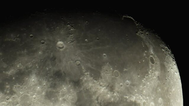 The surface of the Moon with meteorite craters and relief, as seen through an astronomical telescope. Moon on a black background of the night sky