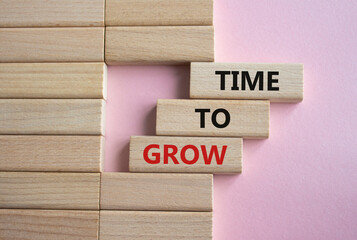 Time to Grow symbol. Concept word Time to Grow on wooden blocks. Beautiful pink background....