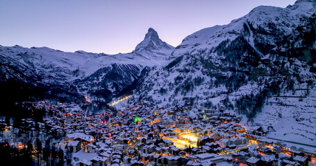 Panoramic landscape of Zermatt city Valley famous travel ski resort and iconic Matterhorn peak at dawn in the swiss alps, Switzerland. The snow covered village and church in Canton Valais in winter. - Powered by Adobe