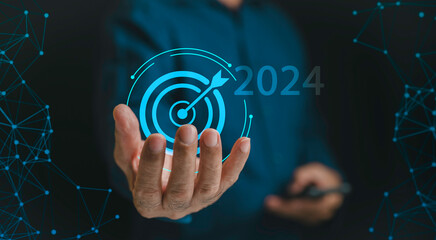 Businessman holding target arrow on hand from 2023 to 2024 for preparation for celebrations new year for new business and start up concept.actionplan and strategi on new business. - obrazy, fototapety, plakaty